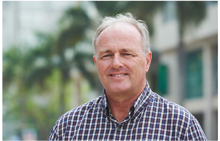 A smiling man with a flanel shirt in his 60s. Eximia Research has a paid norovirus vaccine research study at several locations sites across the US..