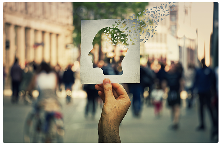 A silhouette of a head with pieces floating away against a crowded backdrop helps to illustrate the cognitive decline and memory loss effects that are common with Alzheimer's disease.